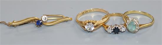 Three assorted 18ct gold and gem set dress rings and a yellow metal sapphire and diamond set bar brooch.